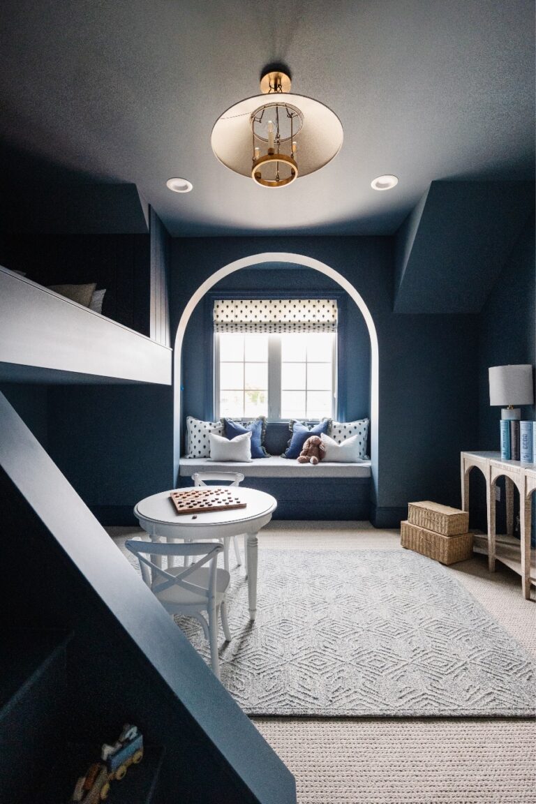 A room with a blue wall and white furniture is illuminated by natural light from an unseen source.